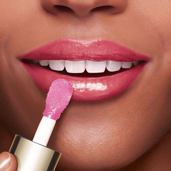 Lippen einer Frau auf die mit Schwämmchenapplikator Clarins Lip Comfort Oil aufgetragen wird um die Wirkung zu zeigen