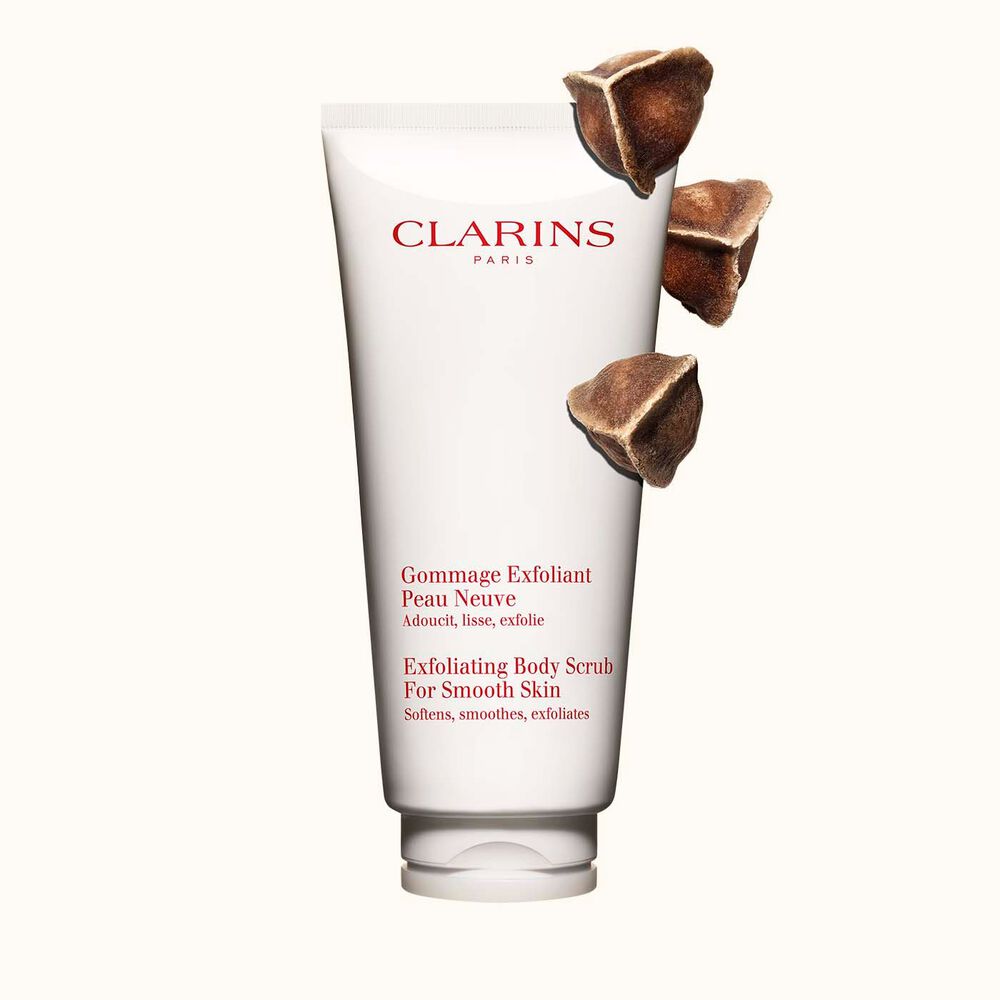 Tube Clarins Gommage Exfoliant Peau Neuve neben Moringa-Samen auf einem beigen Hintergrund
