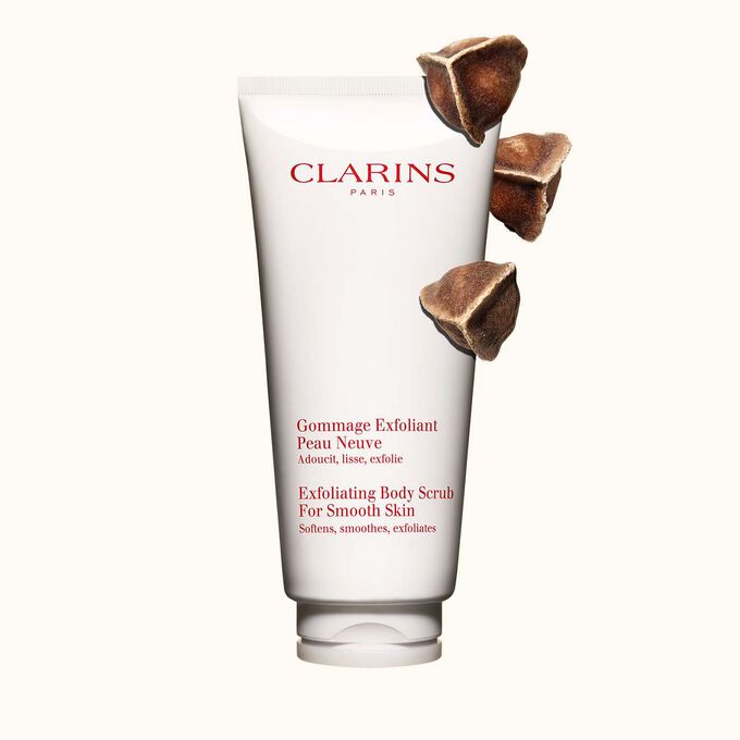 Tube Clarins Gommage Exfoliant Peau Neuve neben Moringa-Samen auf einem beigen Hintergrund